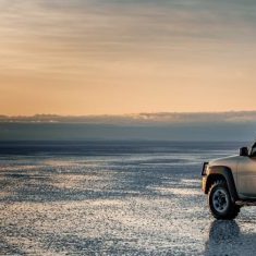 Explore the vast landscape at dawn with an off-road SUV packed for adventure. Perfect for travel enthusiasts.